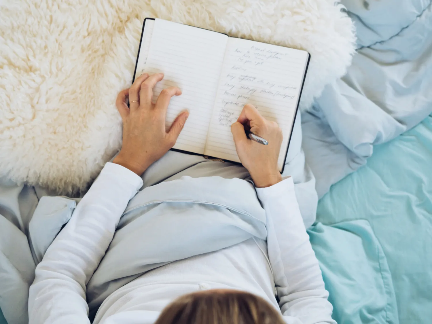 Woman journaling in bed